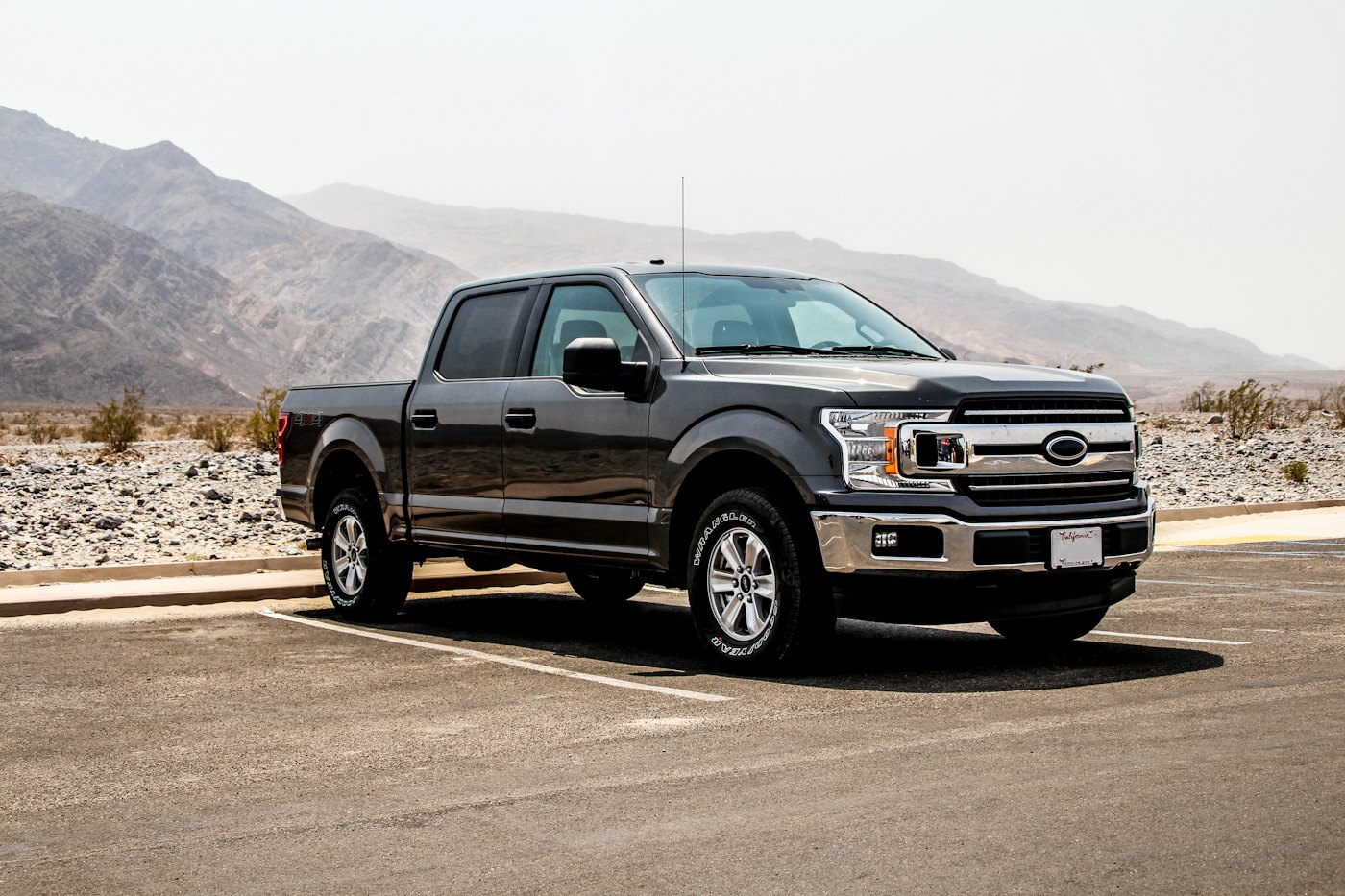 Black pickup truck parked with mountains behind it